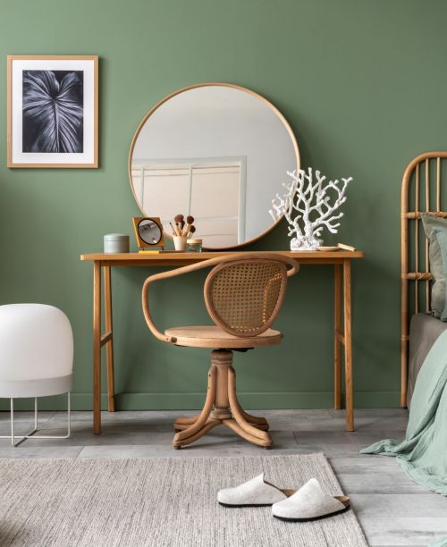 Stylish composition of bedroom in modern glamour interior design with vanity table, big rounded mirror, tropical bed and beautiful personal accessories. Mock up poster. Template.